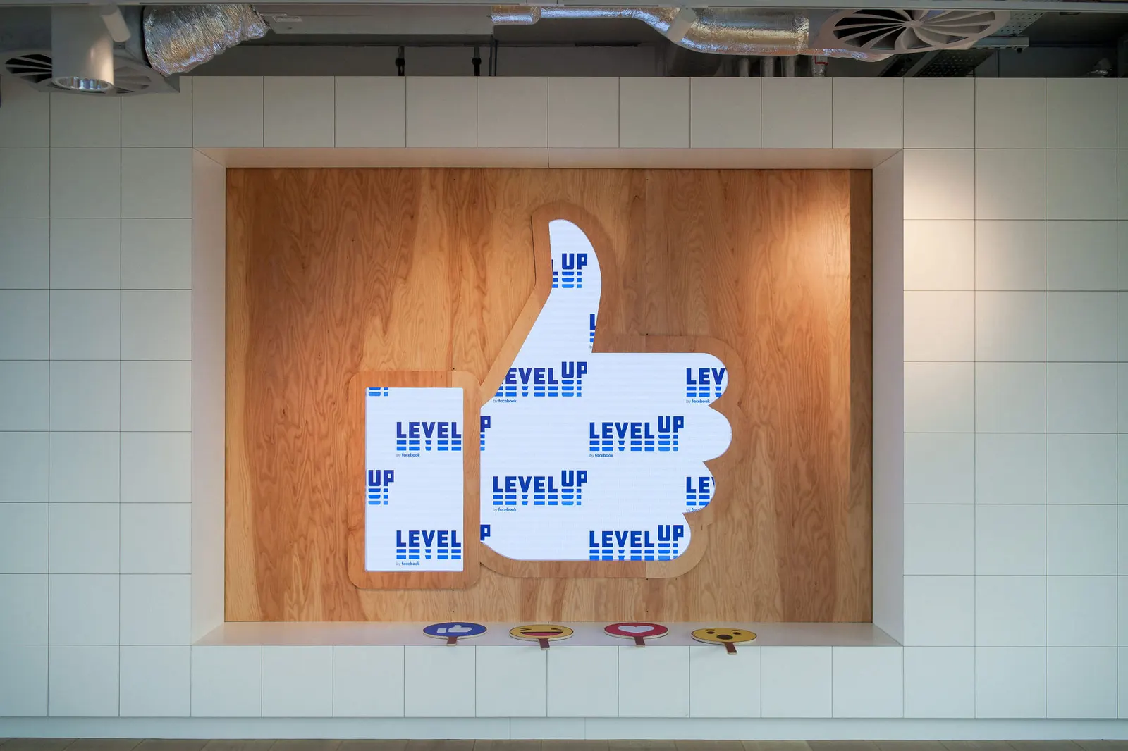 Large Level Up branded thumbs-up sculpture displayed in an office space, photographed by Marquee Visuals.
