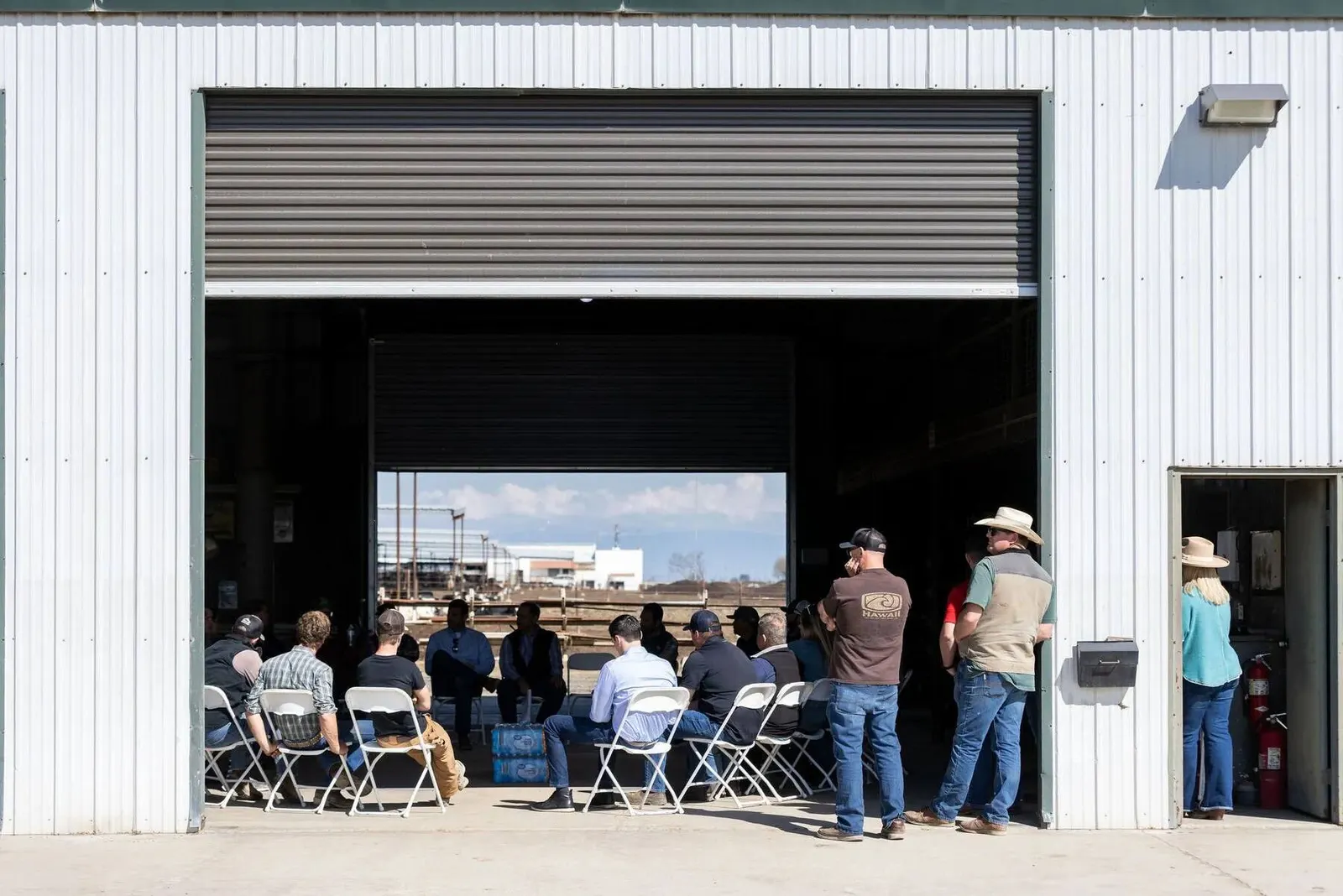 Guests gathered outside an industrial warehouse building with an open bay door at the LOL Hanford event, photographed by Marquee Visuals.