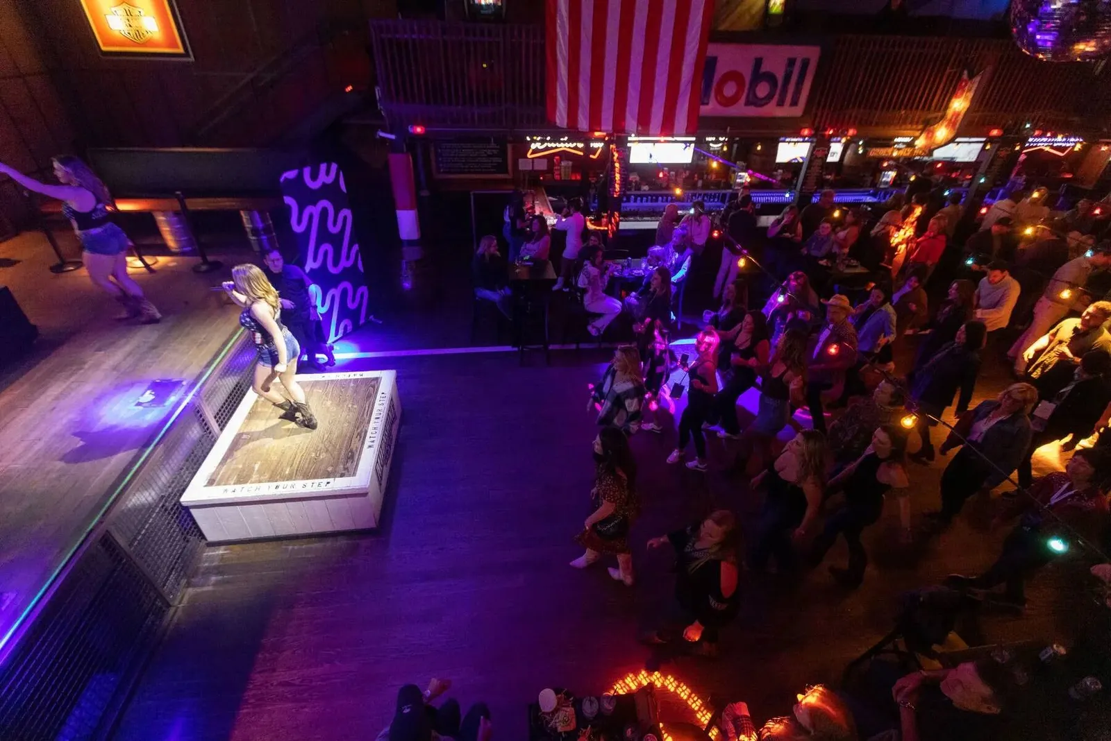 Overhead view of guests dancing at a colorfully lit evening party during the Nadel University 2023 conference, photographed by Marquee Visuals.