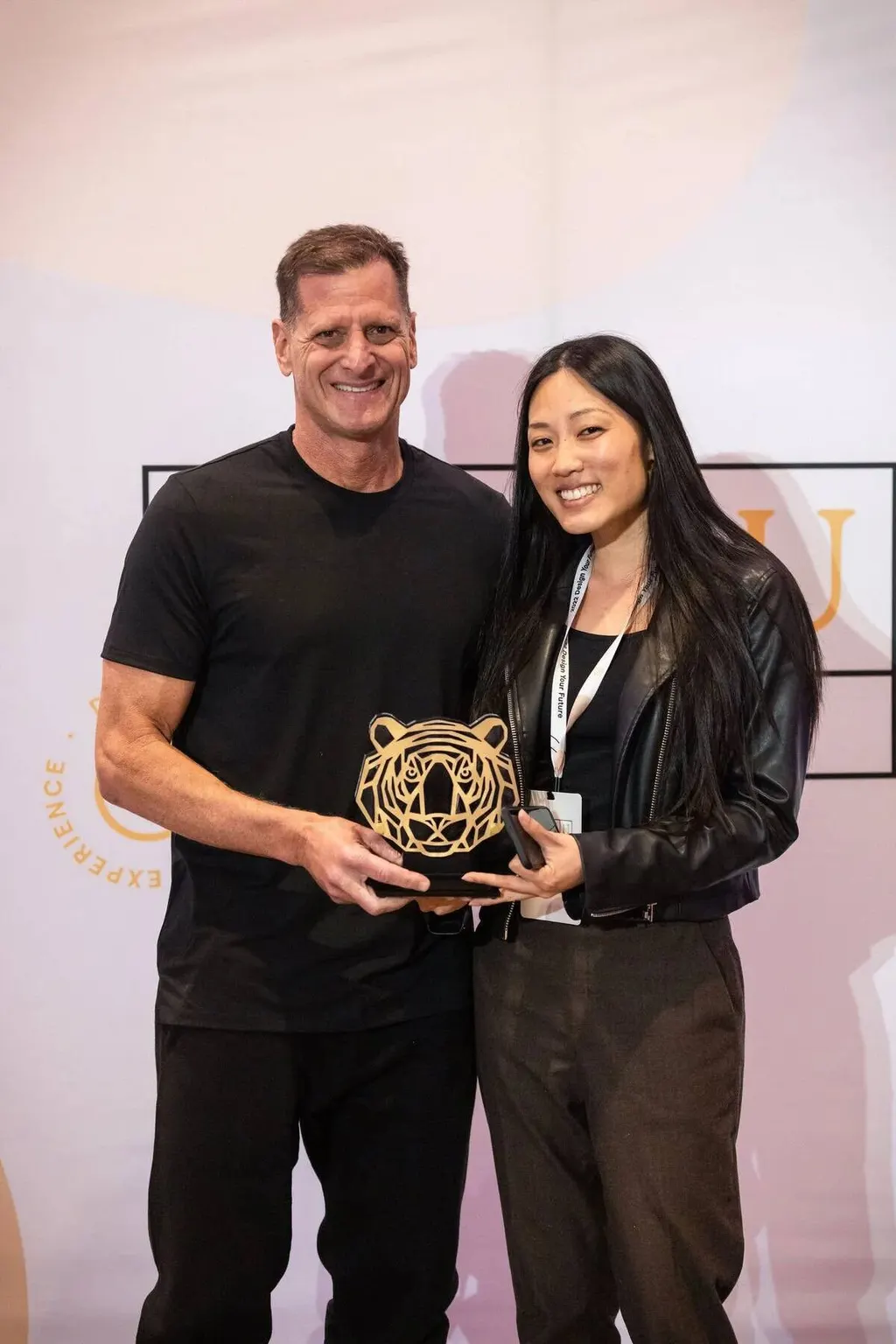 Man and woman posing together with an award trophy at the Nadel University awards ceremony, photographed by Marquee Visuals.