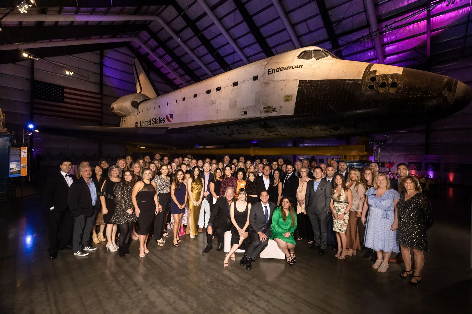 Gala event inside an aircraft hangar with a vintage plane and mingling guests, photographed by Marquee Visuals.