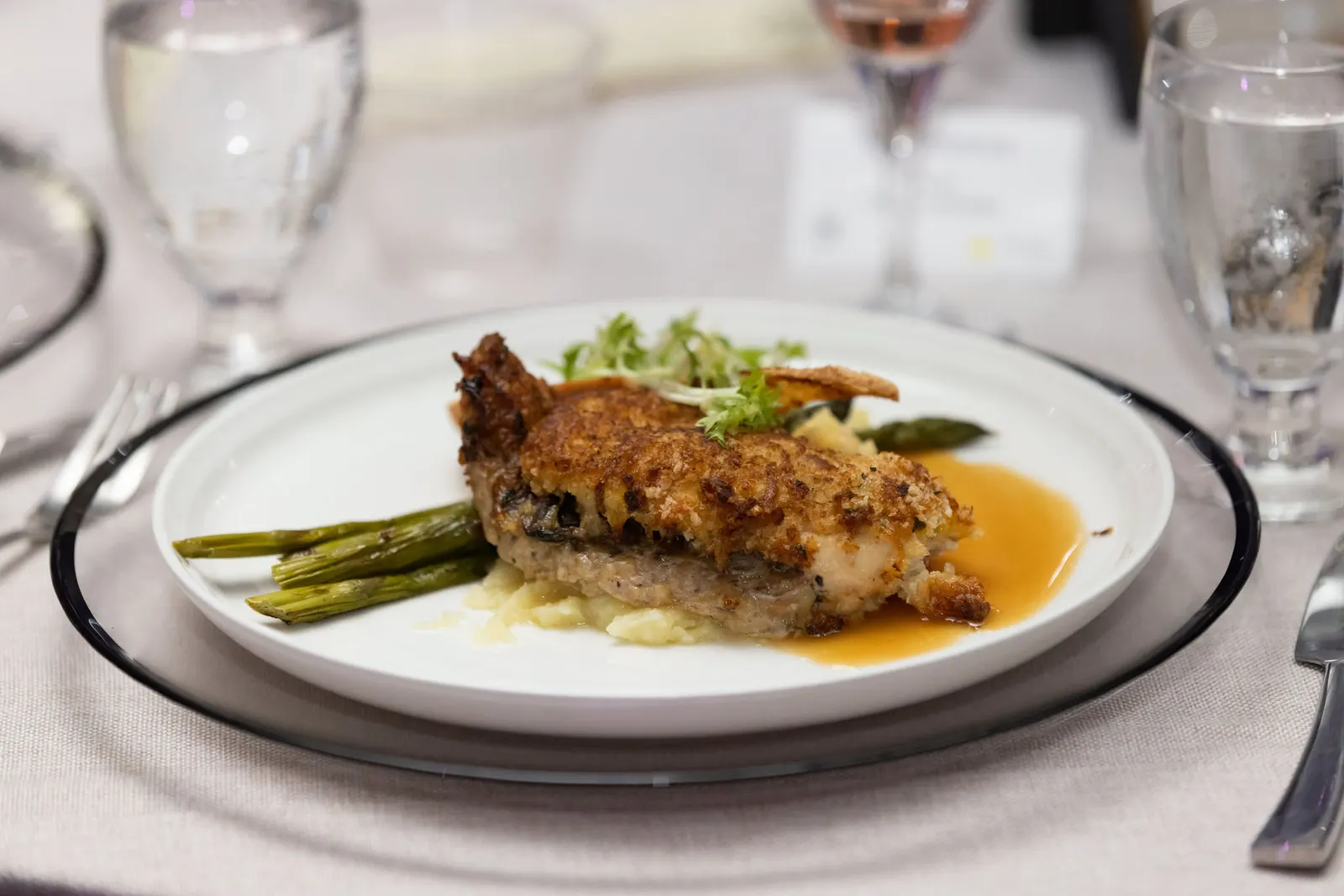 Elegant plated dinner course with asparagus and protein served at a corporate gala, photographed by Marquee Visuals.