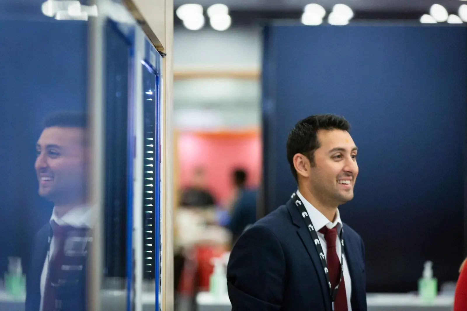 Two attendees in suits sharing a candid moment at the NMSDC Level Up event, photographed by Marquee Visuals.