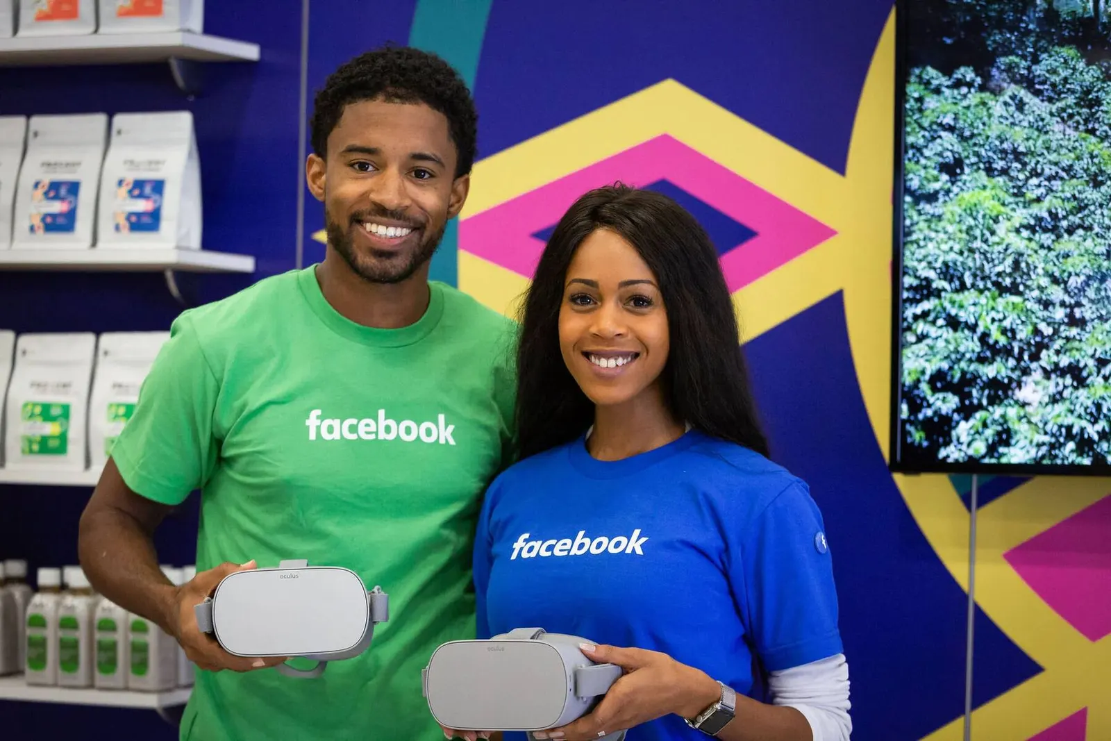 Two people in green Facebook shirts holding VR headsets at the NMSDC Level Up trade show booth, photographed by Marquee Visuals.