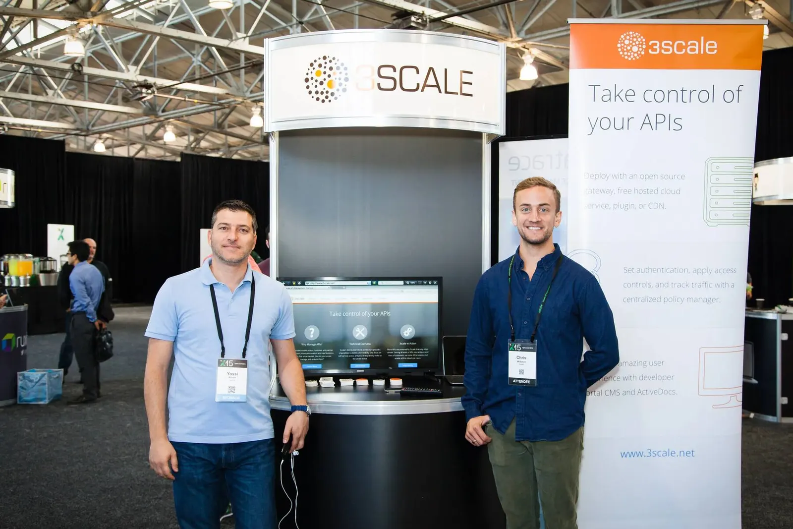 Two attendees posing at a Scale conference trade show booth with digital displays, photographed by Marquee Visuals in the Bay Area.