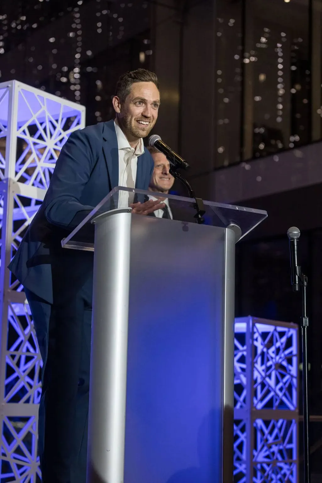 Speaker presenting at a podium on stage at the Tiger Gala, photographed by Marquee Visuals.