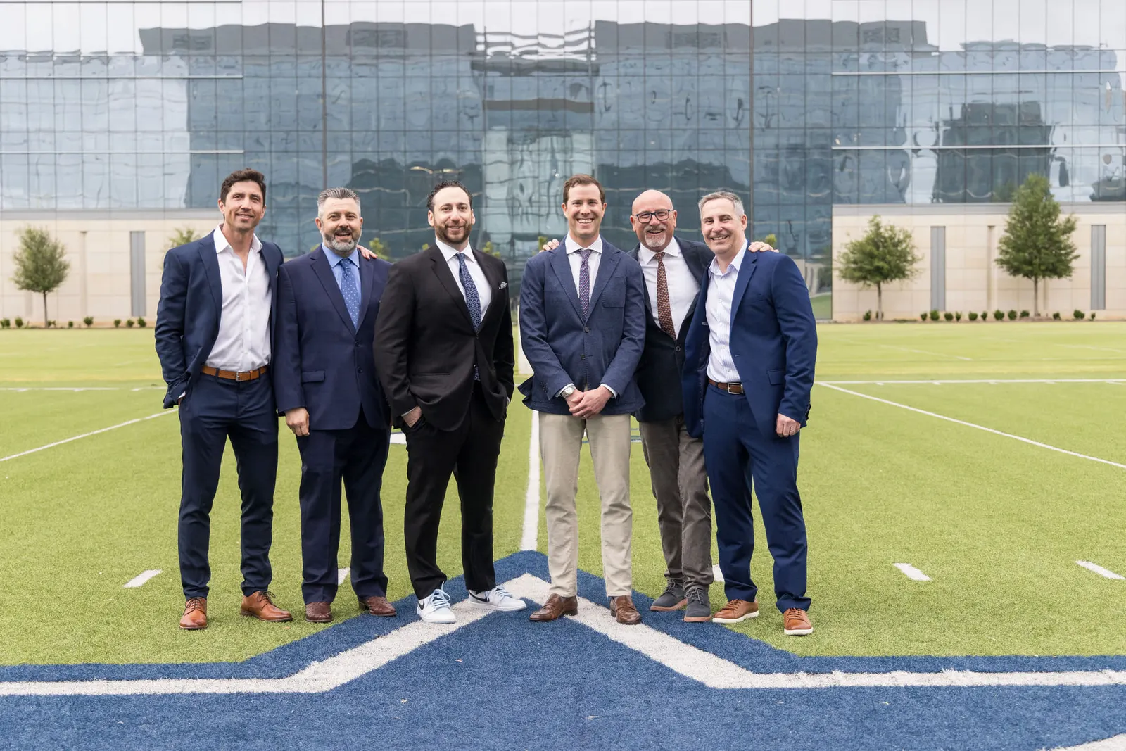 Small group of attendees posing at a football stadium exterior, photographed by Marquee Visuals in Los Angeles.