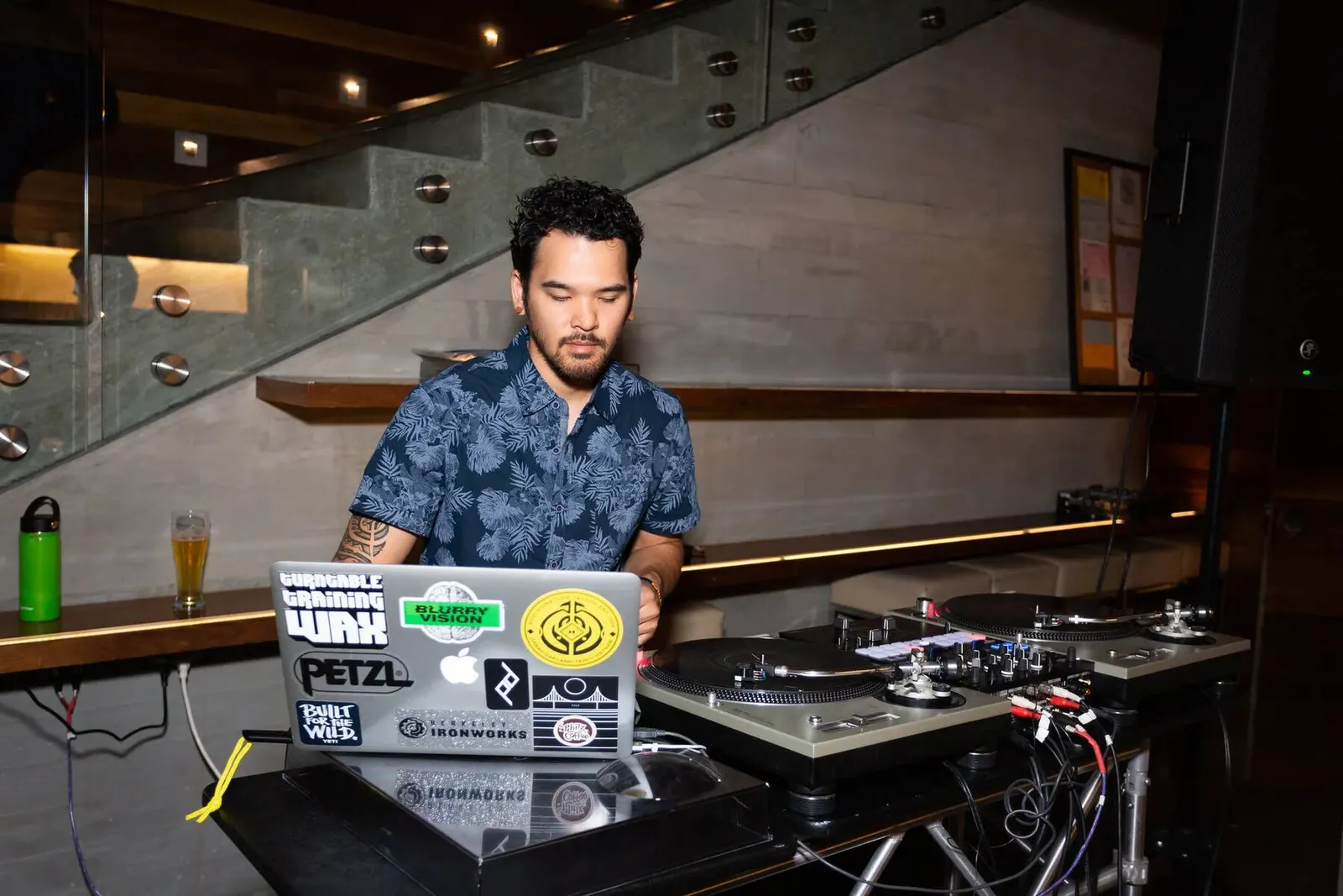 DJ performing on a laptop mixing setup at the Tron Happy Hour event, photographed by Marquee Visuals.