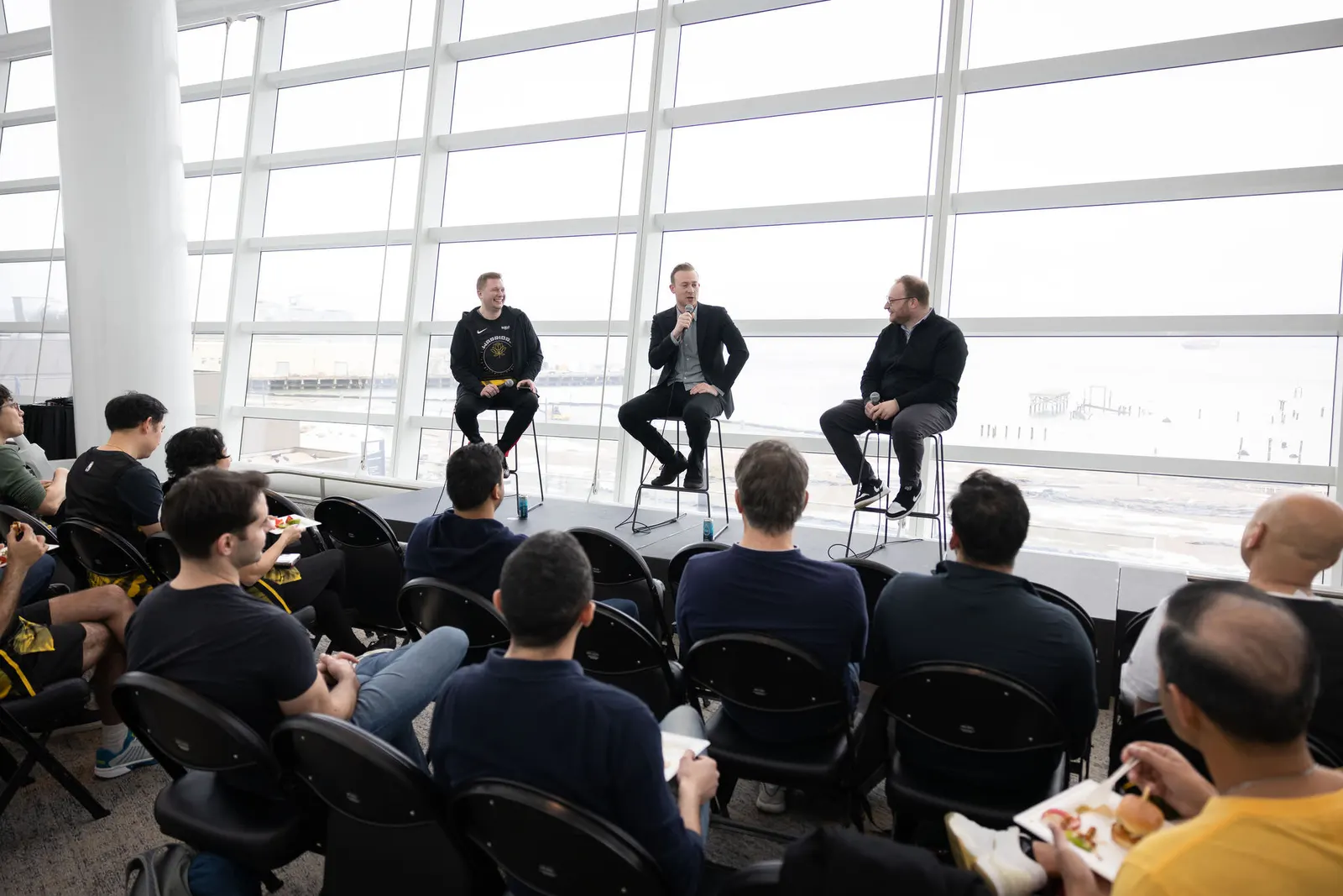 Candid shot of event attendees seated in a glass-walled arena space, photographed by Marquee Visuals in the Bay Area.