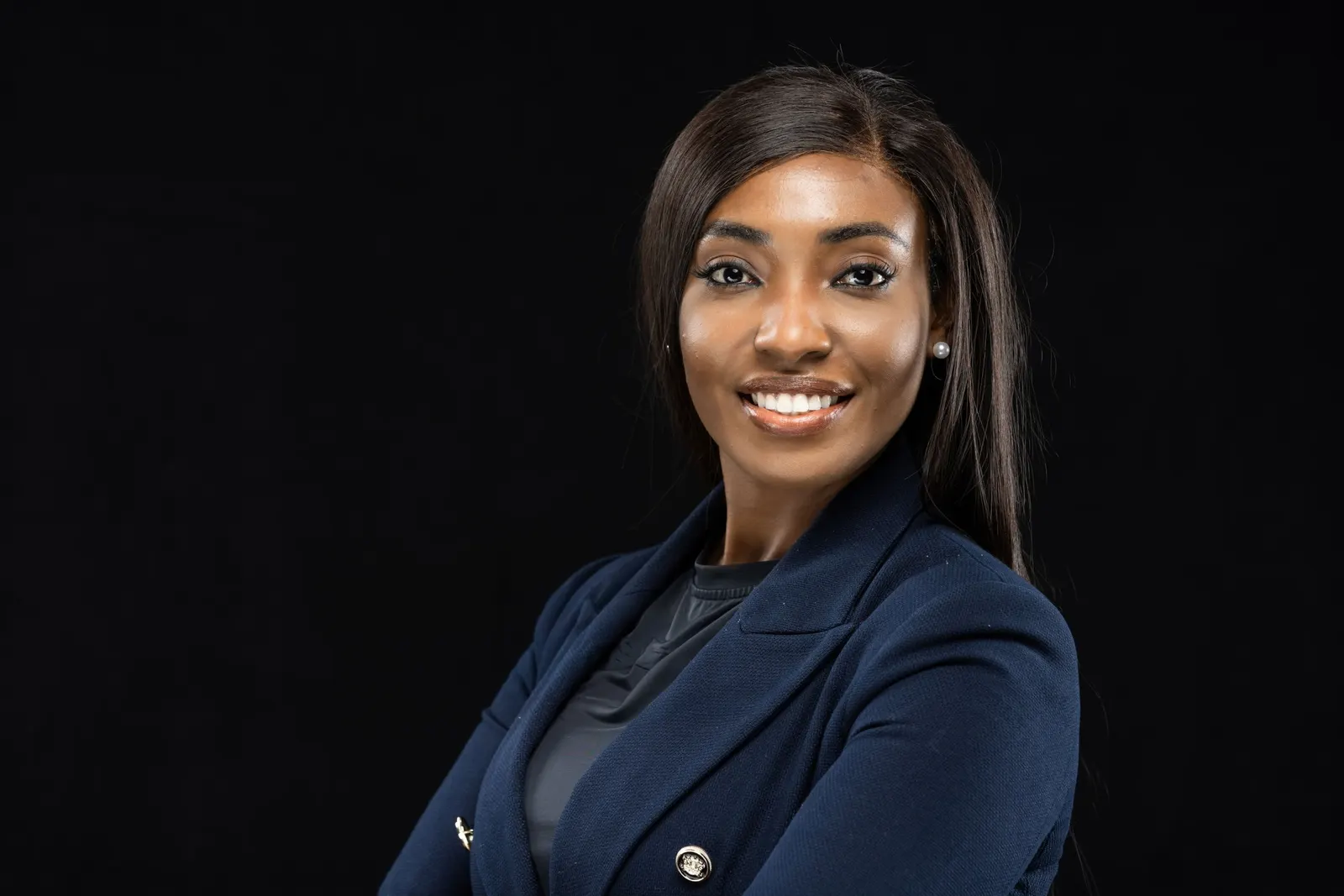 Corporate headshot of a confident woman in a navy blazer on a black studio backdrop, photographed by Marquee Visuals in Los Angeles.